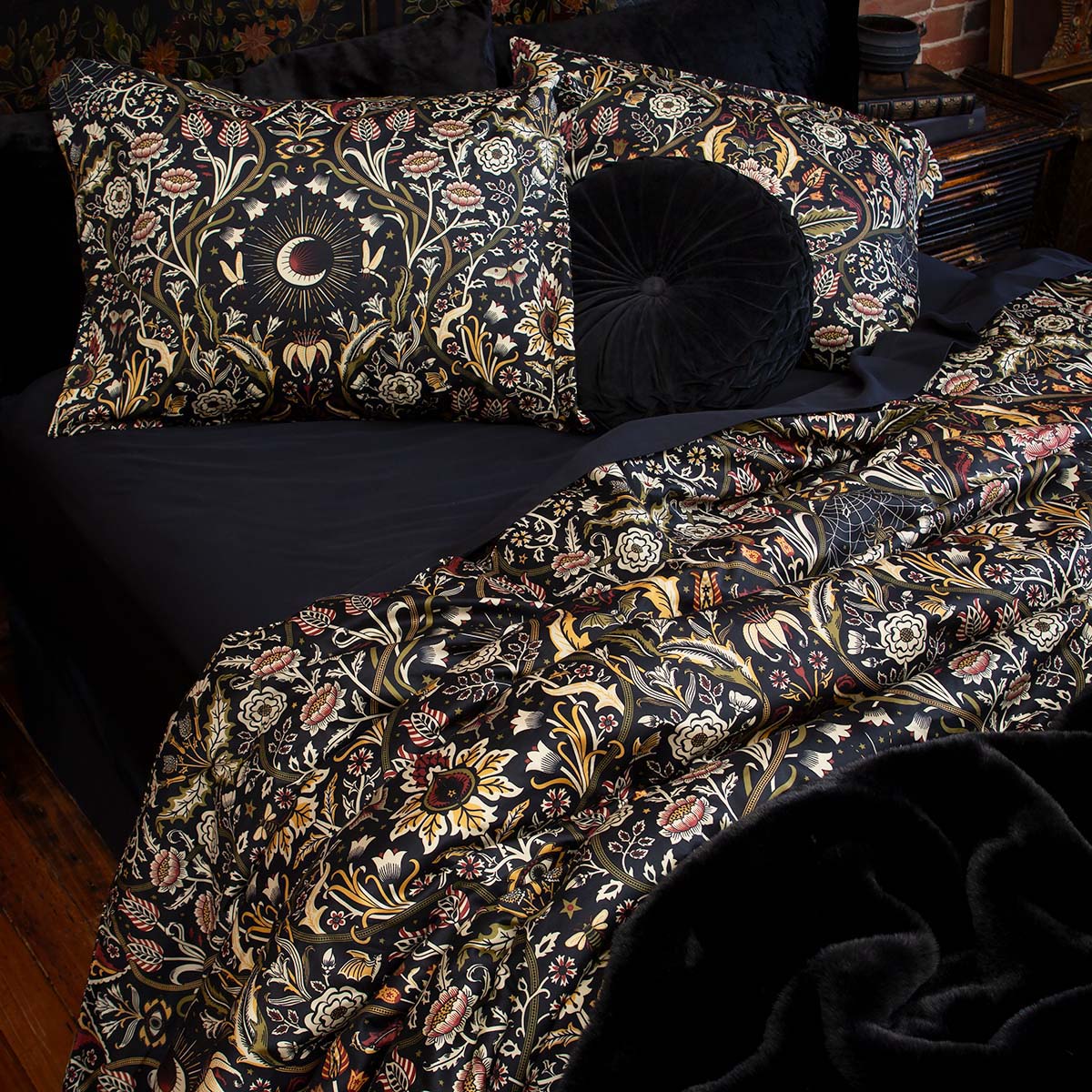 Night Garden in Harvest colorway on a bed with black bamboo bedding. Botanicals in burgundy & moss