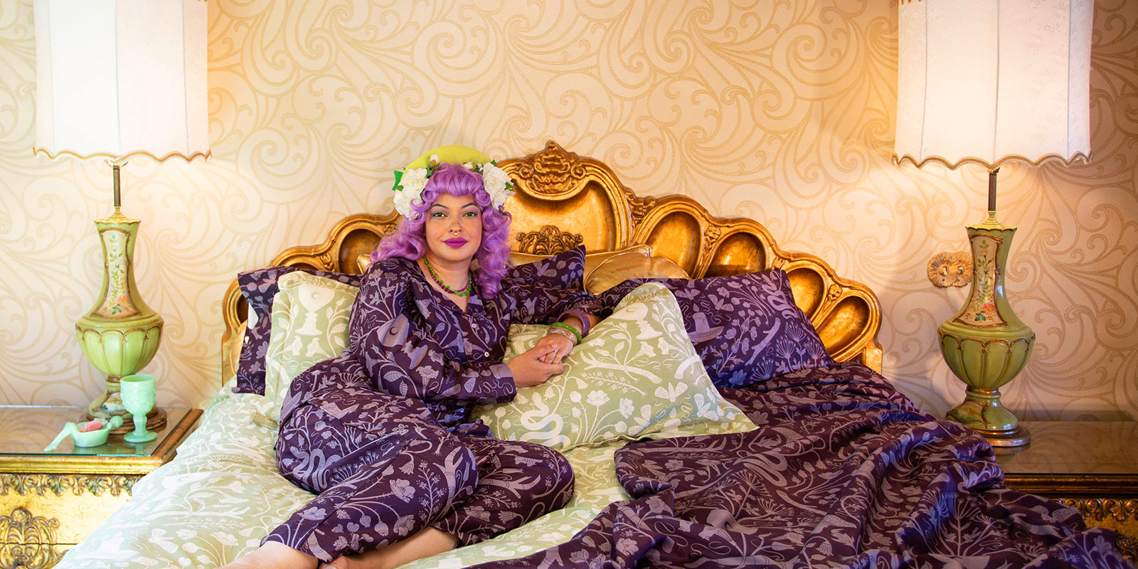 Lady laying on Sin in Linen Alchemy Green Bedding at Madonna Inn