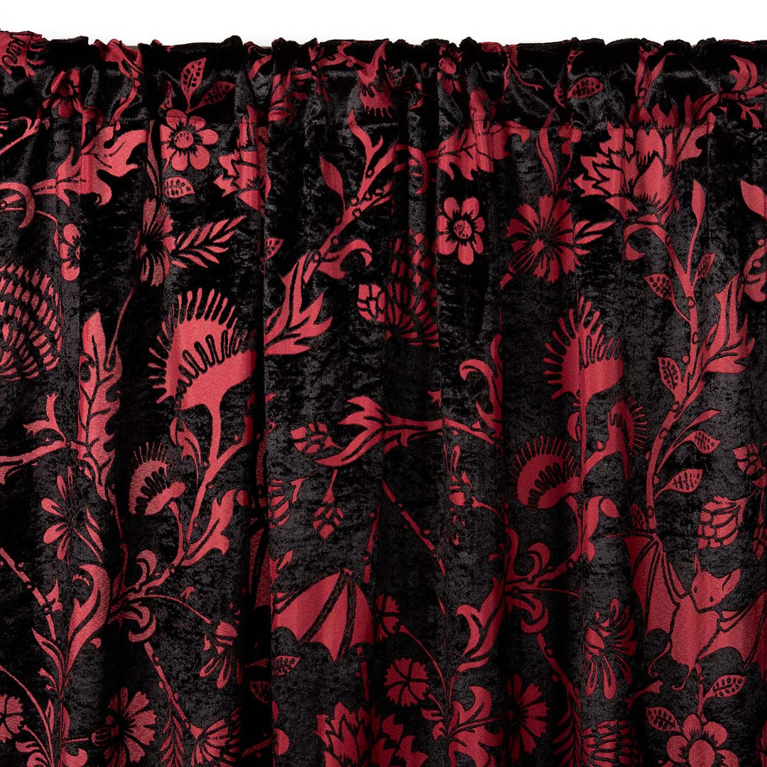 Burgundy red and black velvet curtain with a gothic botanical pattern featuring bats and venus fly traps. 