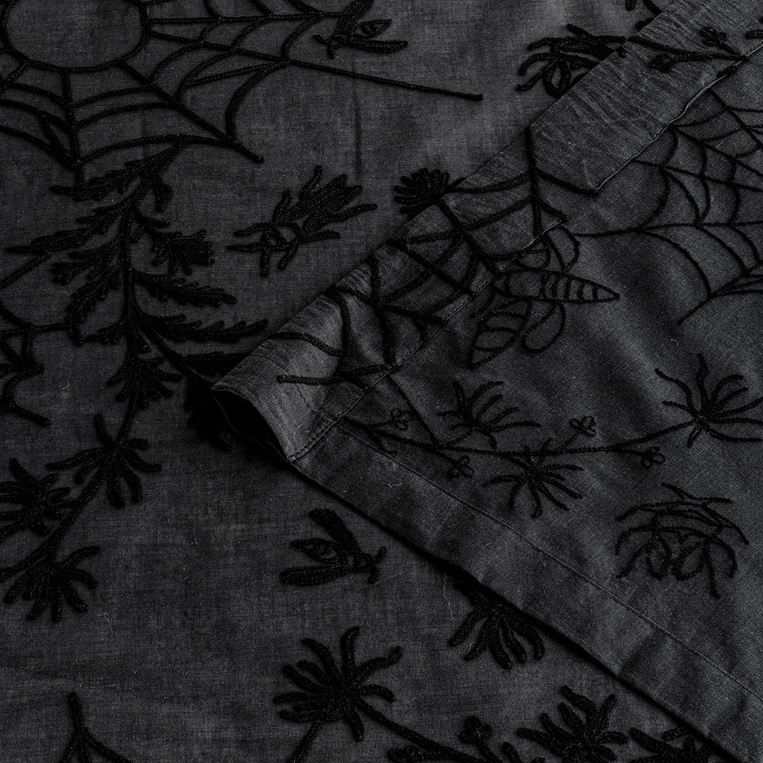 Corner of black cotton curtains with black spider web embroidery. Cottagecore and whimsigoth decor by Sin in Linen.