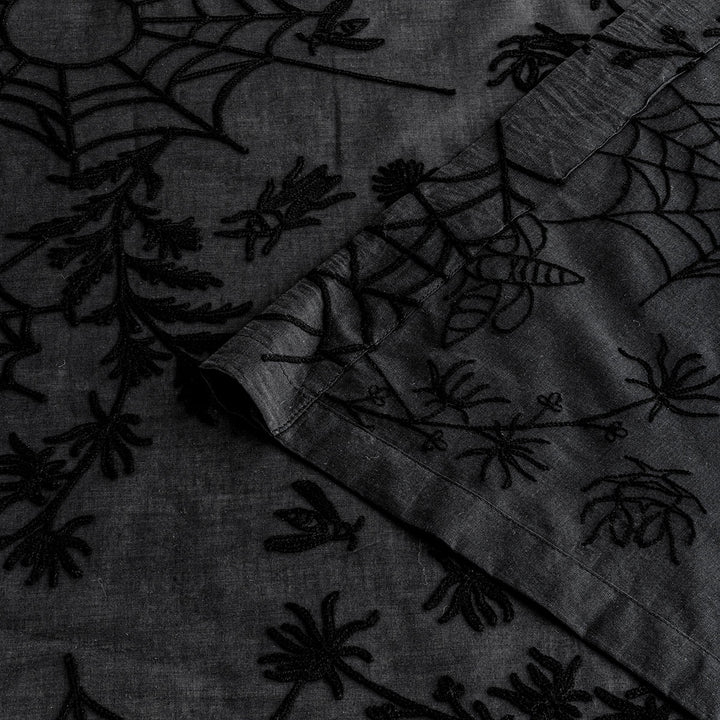Corner of black cotton curtains with black spider web embroidery. Cottagecore and whimsigoth decor by Sin in Linen.