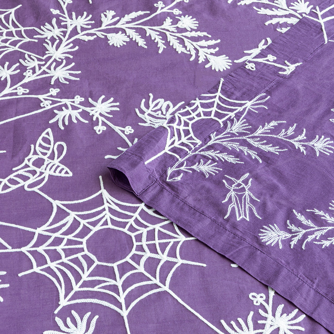 Corner of purple cotton curtains with ivory spider web embroidery. Cottagecore and whimsigoth decor by Sin in Linen.