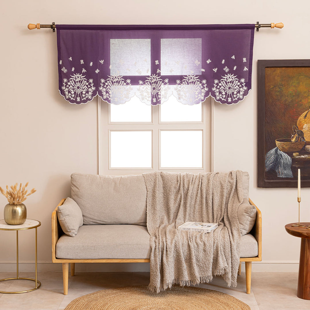 Purple cotton window valance and curtains with ivory spider web cottagecore and whimsigoth embroidery. The window valance is hung above a couch in a living room.