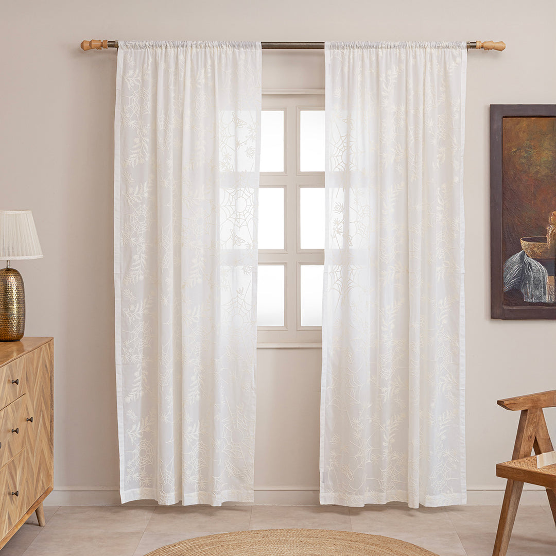 Ivory cotton curtains with ivory spider web embroidery. Curtains are hung up in a living room. Cottagecore and whimsigoth decor by Sin in Linen.