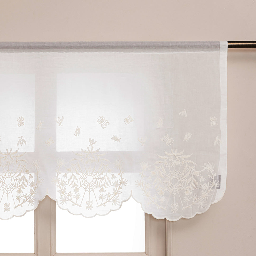 Ivory cotton window valance and curtains with ivory spider web cottagecore and whimsigoth embroidery hung up in a window.