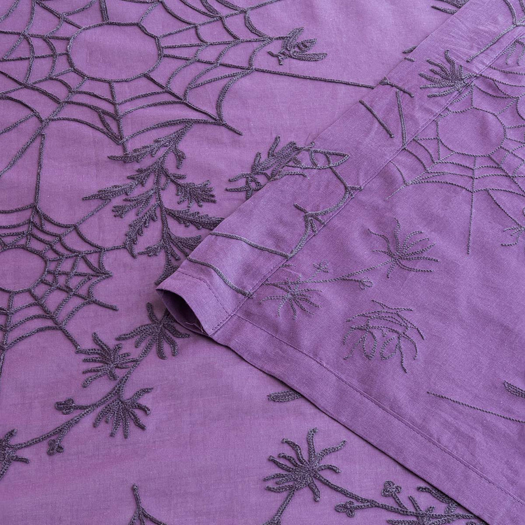 Corner of purple cotton curtains with purple spider web cottagecore and whimsigoth embroidery.