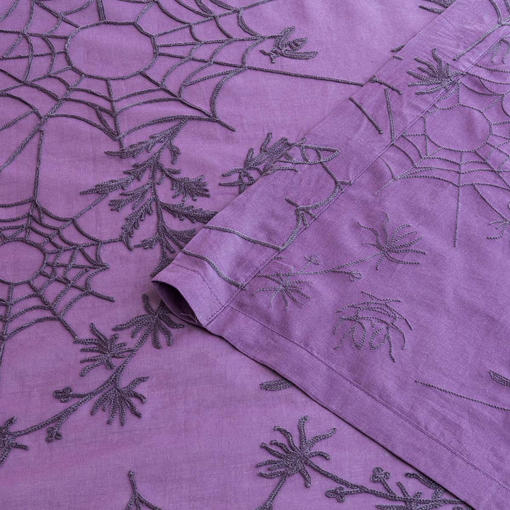 Corner of purple cotton curtains with purple spider web cottagecore and whimsigoth embroidery.