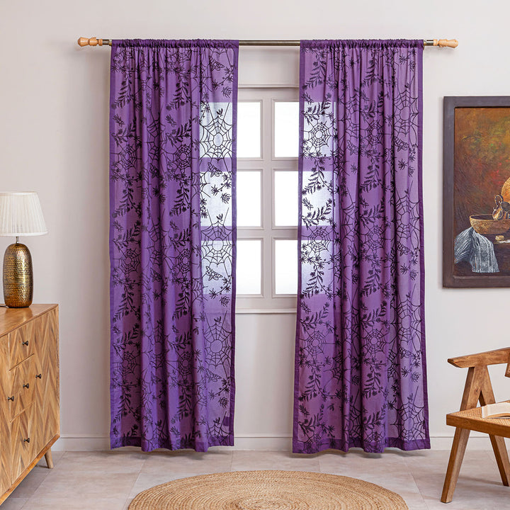 Purple cotton curtains with purple spider web cottagecore and whimsigoth embroidery. Hung up on a curtain rod in a living room.