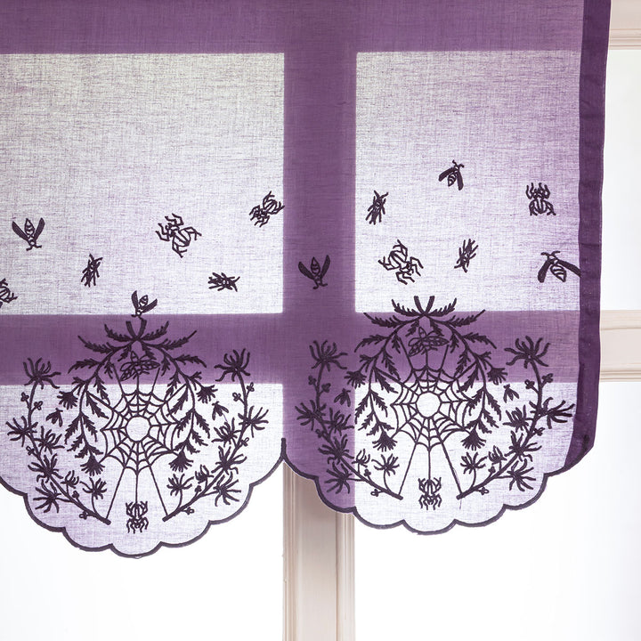 Decorative window valance with spider and web patterns embroidered on a purple cotton.