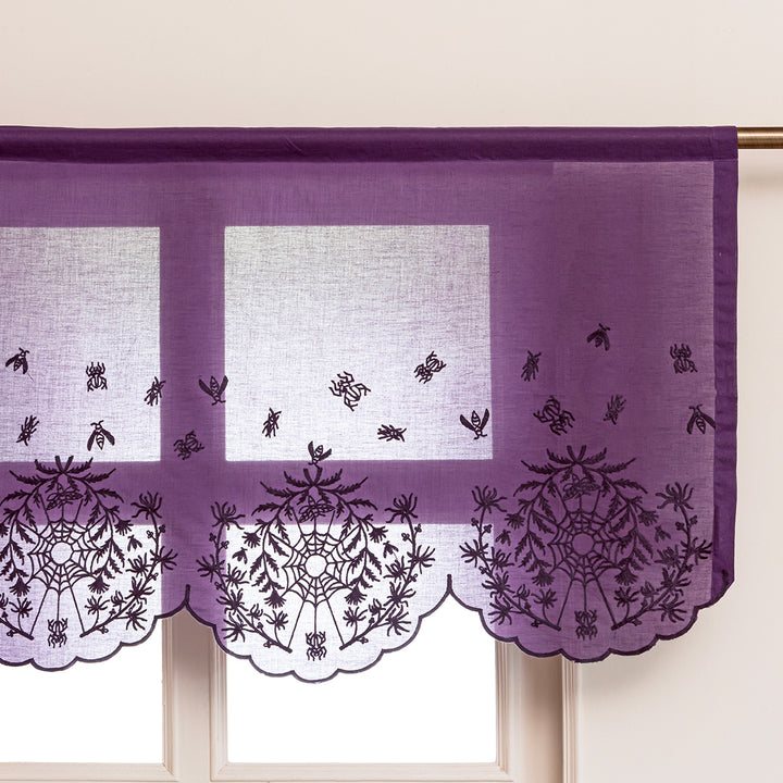 Decorative window valance with spider and web patterns embroidered on a purple cotton.