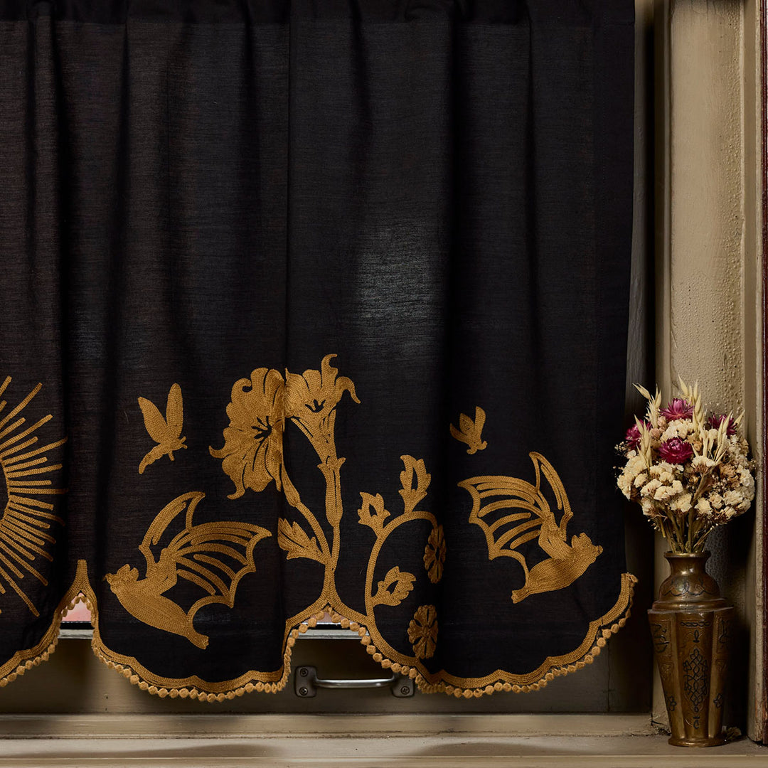 Sin in Linen's Embroidered Night Garden Valances with scalloped edges. Witchy motifs of moons and florals meet classic bronze and black colors for something truly special. 