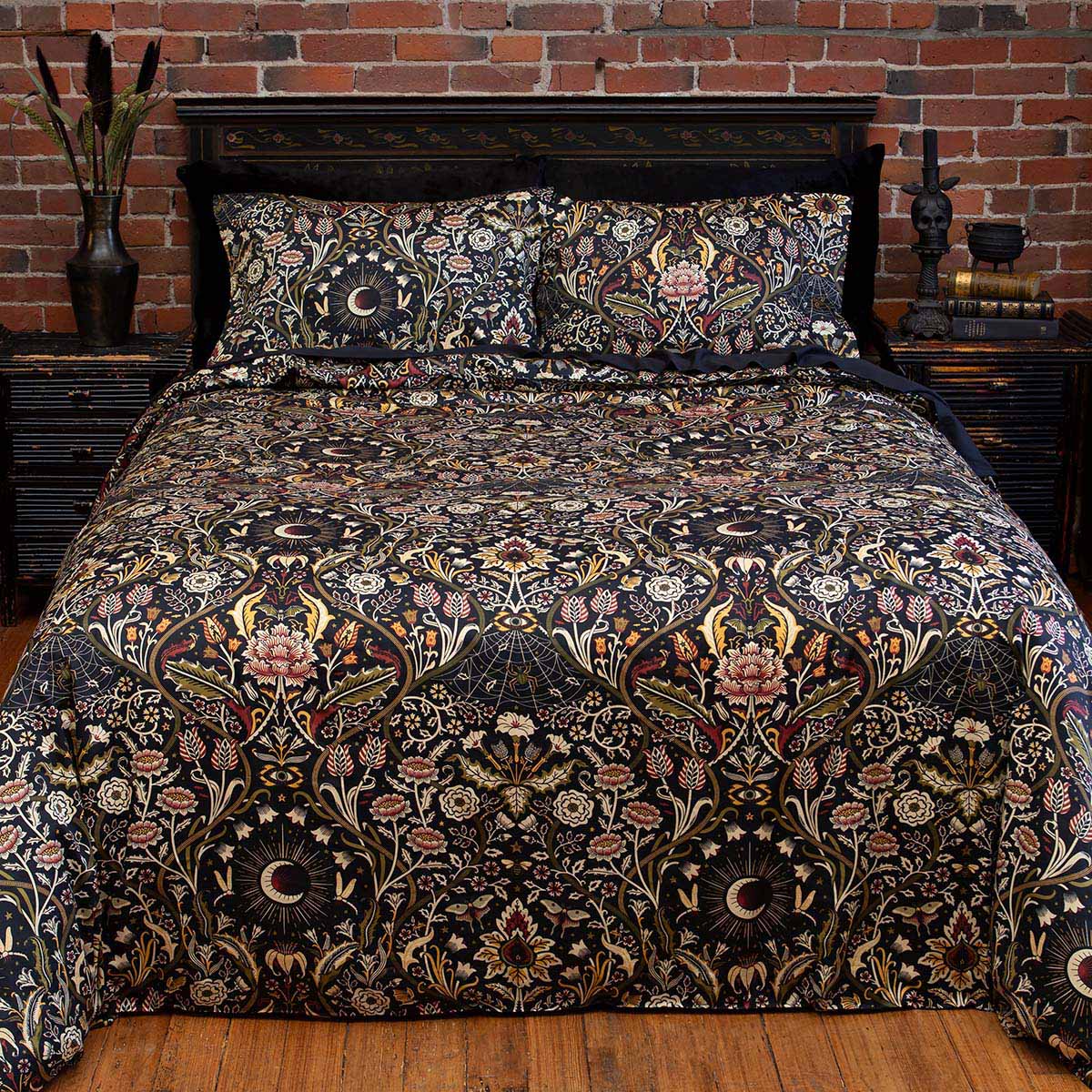 Night Garden Harvest botanical bedding on a bed. Features florals, serpents, and spiders for a nature inspired bedroom. 