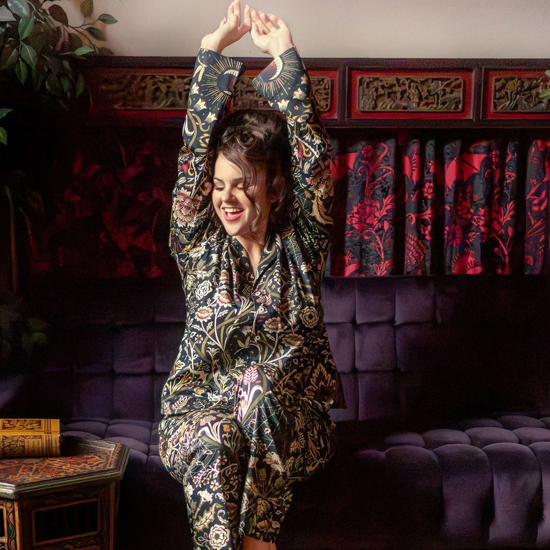 Gothic botanical pajamas on a happy woman. Hues of burgundy and moss green dark floral print.