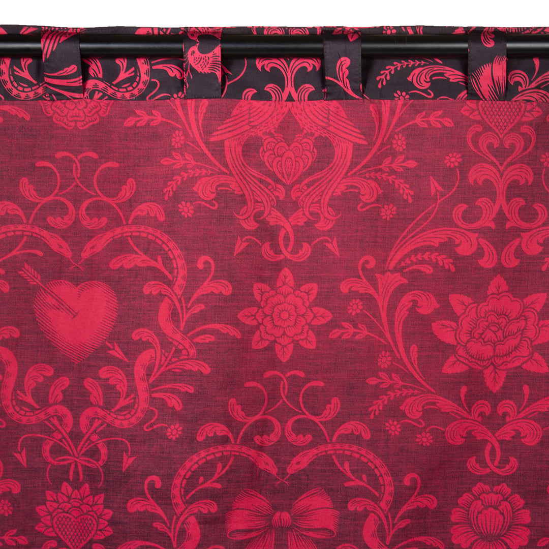 Back of the Love Bound curtain by Sin in Linen featuring a black background and a dark blush colored pattern with pierced hearts, serpents, and bows. Romantic rococo inspired design. 