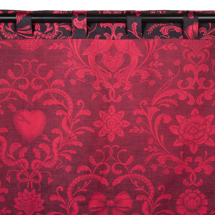 Back of the Love Bound curtain by Sin in Linen featuring a black background and a dark blush colored pattern with pierced hearts, serpents, and bows. Romantic rococo inspired design. 