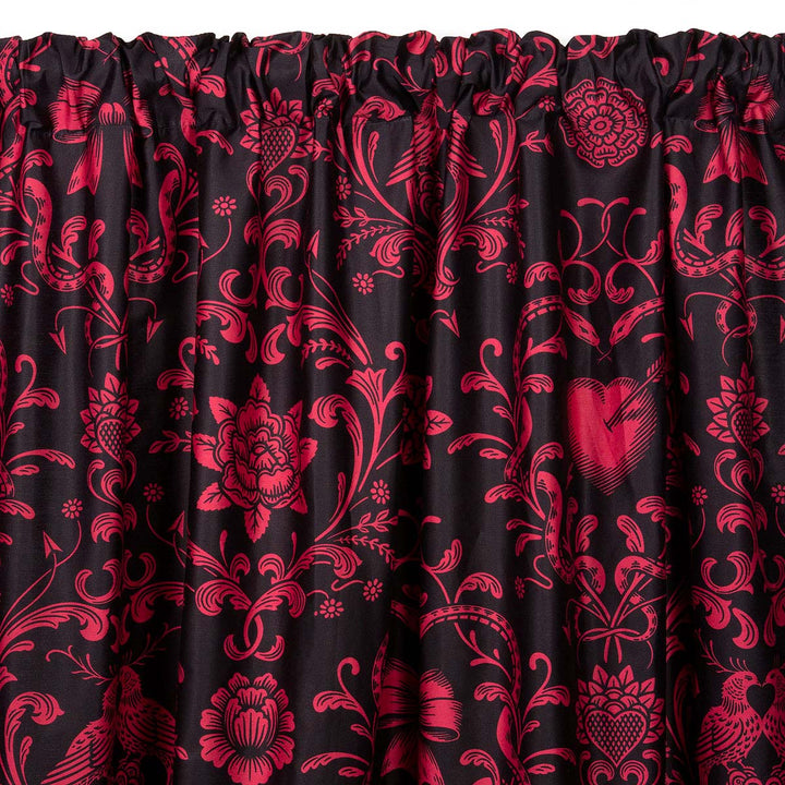 Love Bound curtain by Sin in Linen featuring a black background and a dark blush colored pattern with pierced hearts, serpents, and bows. Romantic rococo inspired design. 