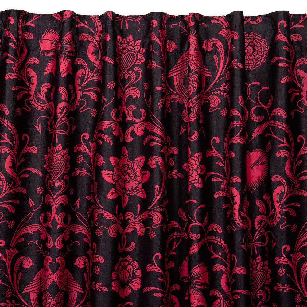 Love Bound curtain by Sin in Linen featuring a black background and a dark blush colored pattern with pierced hearts, serpents, and bows. Romantic rococo inspired design. 