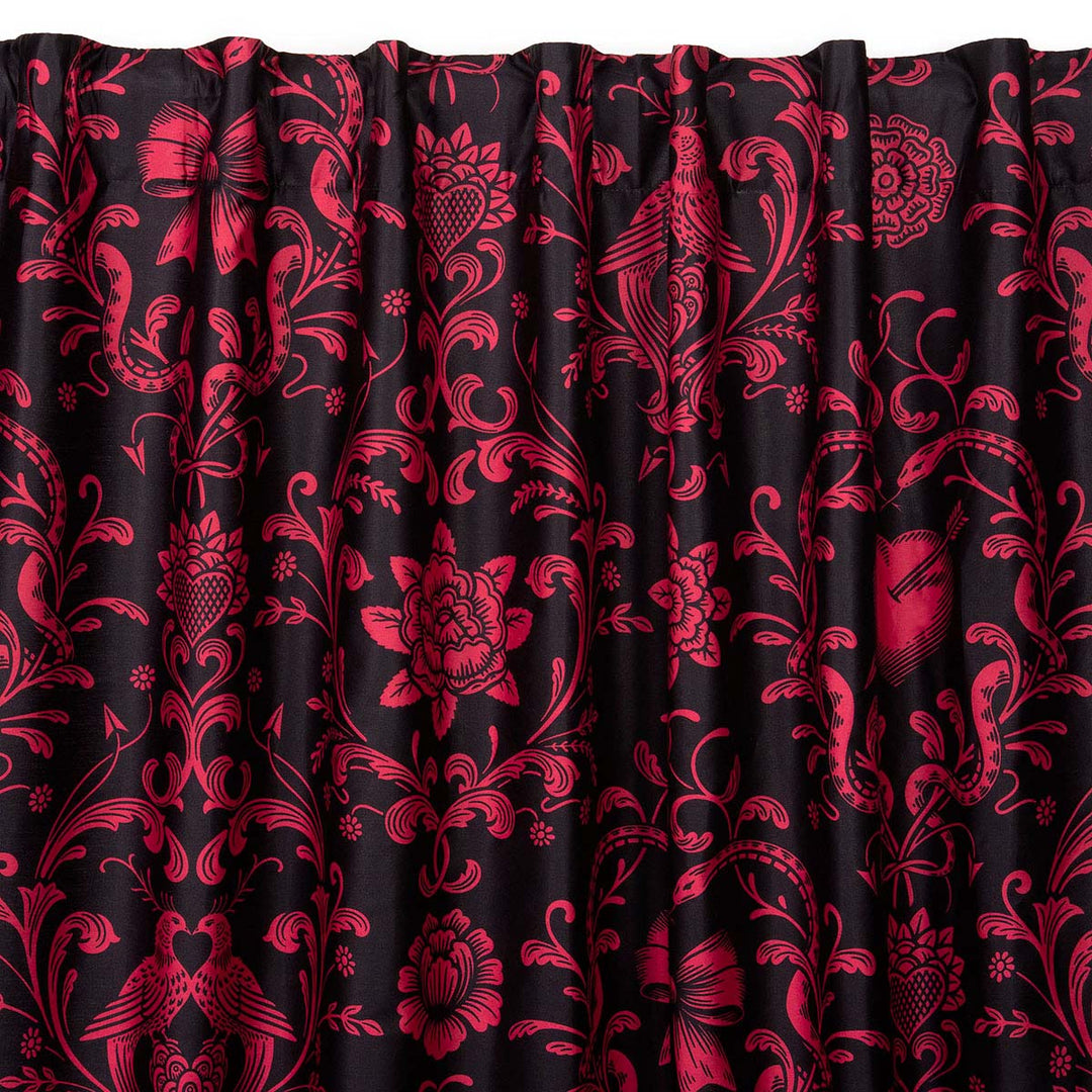 Love Bound curtain by Sin in Linen featuring a black background and a dark blush colored pattern with pierced hearts, serpents, and bows. Romantic rococo inspired design. 