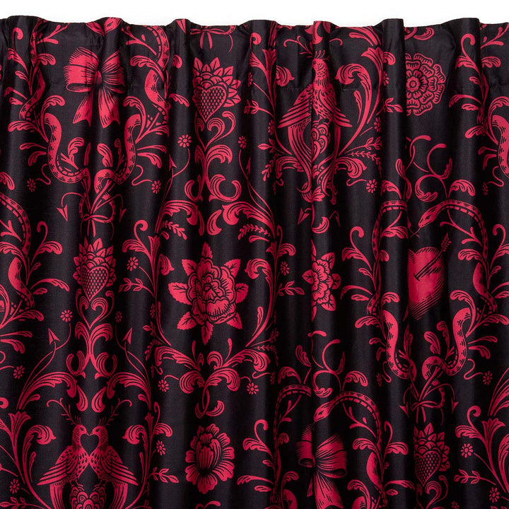 Love Bound curtain by Sin in Linen featuring a black background and a dark blush colored pattern with pierced hearts, serpents, and bows. Romantic rococo inspired design. 