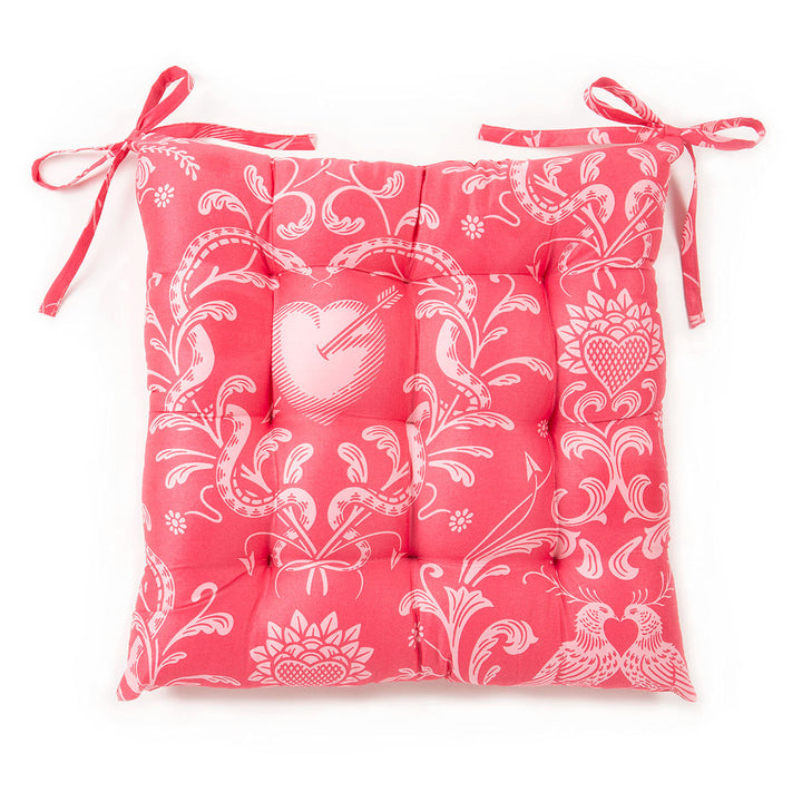 White background image of Sin in Linen's Love Bound Rose chair pad with a tufted top. 