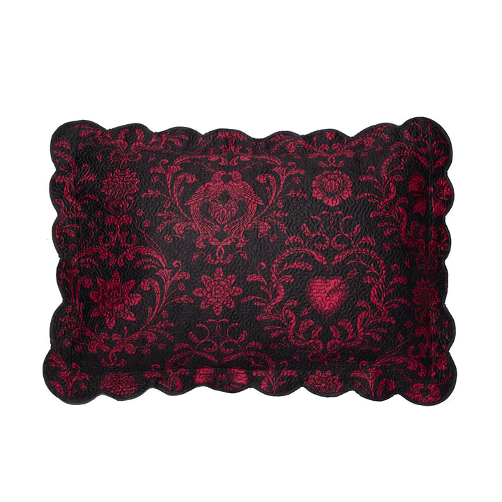 Quilted sham featuring pierced hearts, serpents, and bows in pink and black. 