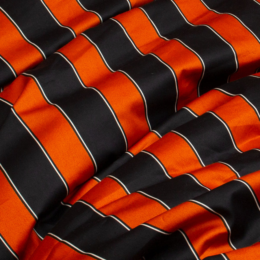 Pumpkin orange and black stripe cotton swatch used for home decor products. Vintage circus inspired decor for gothic interiors. 