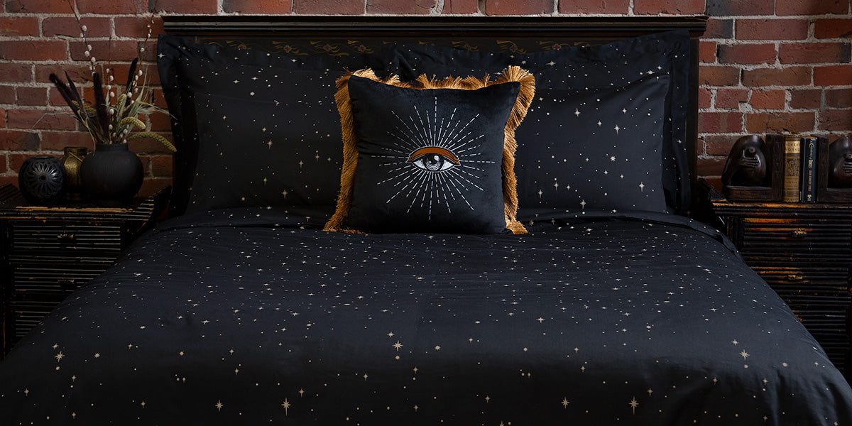 Celestial inspired bedding by Sin in Linen featuring bronze stars and coordinating decor. 