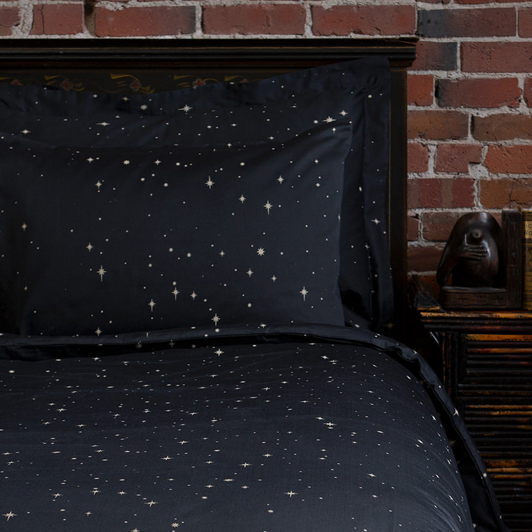 Pillowcases featuring a bronze star print for a celestial bohemian bedroom. Bedding by Sin in Linen. 