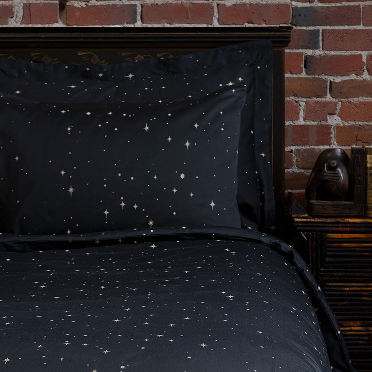 Pillowcases featuring a bronze star print for a celestial bohemian bedroom. Bedding by Sin in Linen. 