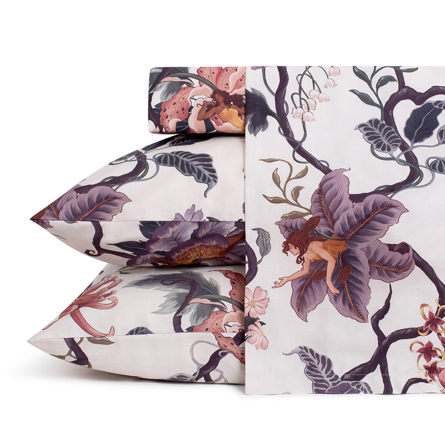 Romantic floral bedding by Sin in Linen. Nymphs bloom out of flowers on a light background in this fairy inspired sheet set. Hues of lilac and rose abound. 