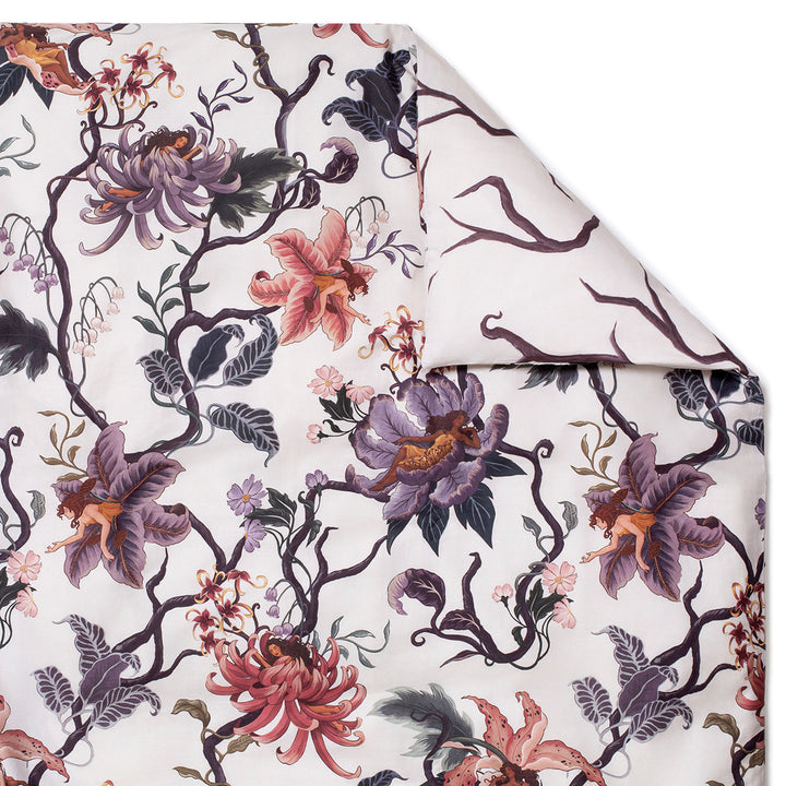 Romantic floral bedding by Sin in Linen. Nymphs bloom out of flowers on a light background on this fairy inspired duvet cover. Hues of lilac and rose abound on this reversible bedding.