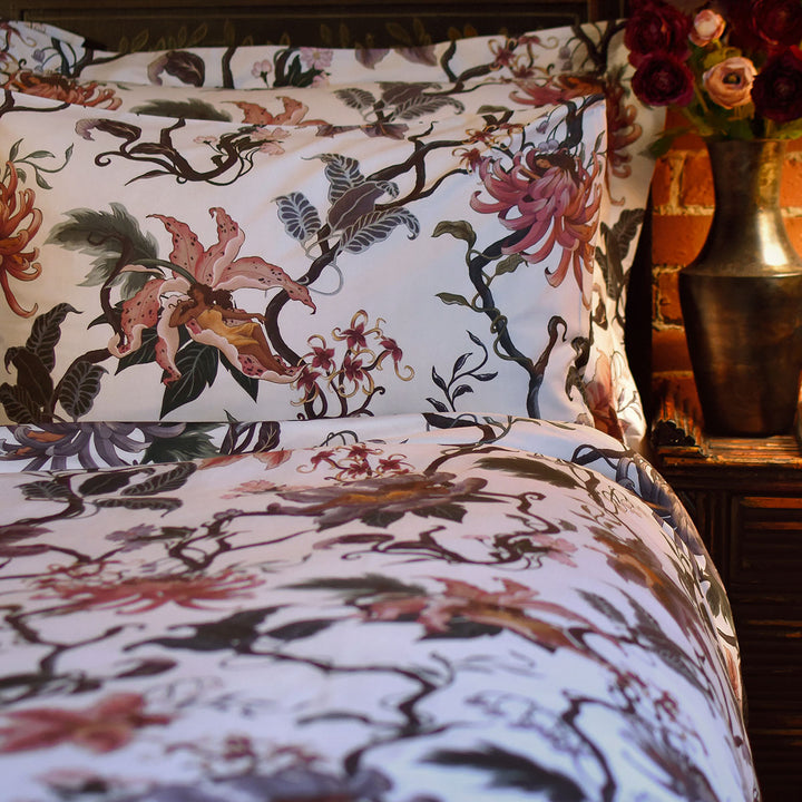 Romantic floral bedding by Sin in Linen. Nymphs bloom out of flowers on a light background in this fairy inspired bedding collection. Hues of lilac and rose abound. 