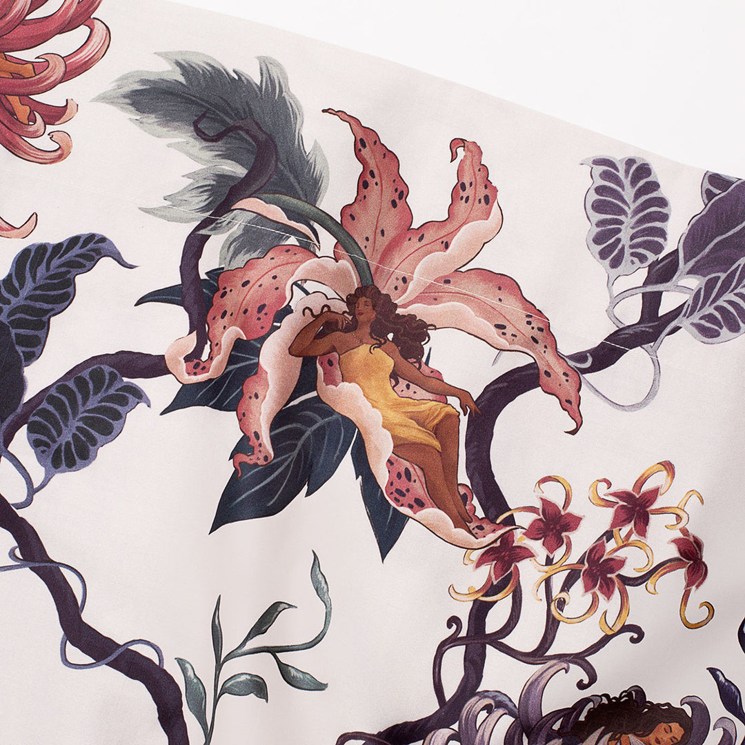 Romantic floral bedding by Sin in Linen. Nymphs bloom out of flowers on a light background in this fairy inspired bedding collection. Hues of lilac and rose abound. 