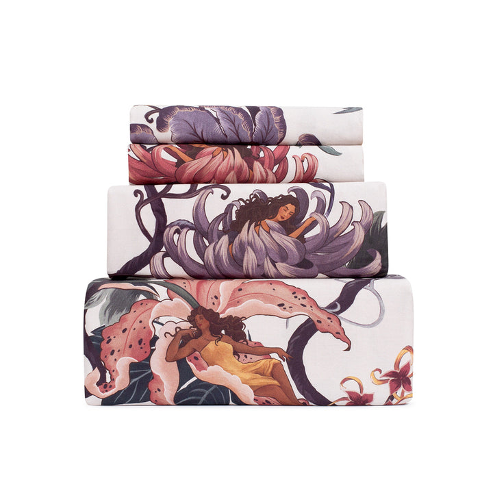 Romantic floral bedding by Sin in Linen. Nymphs bloom out of flowers on a light background in this fairy inspired sheet set. Hues of lilac and rose abound. 