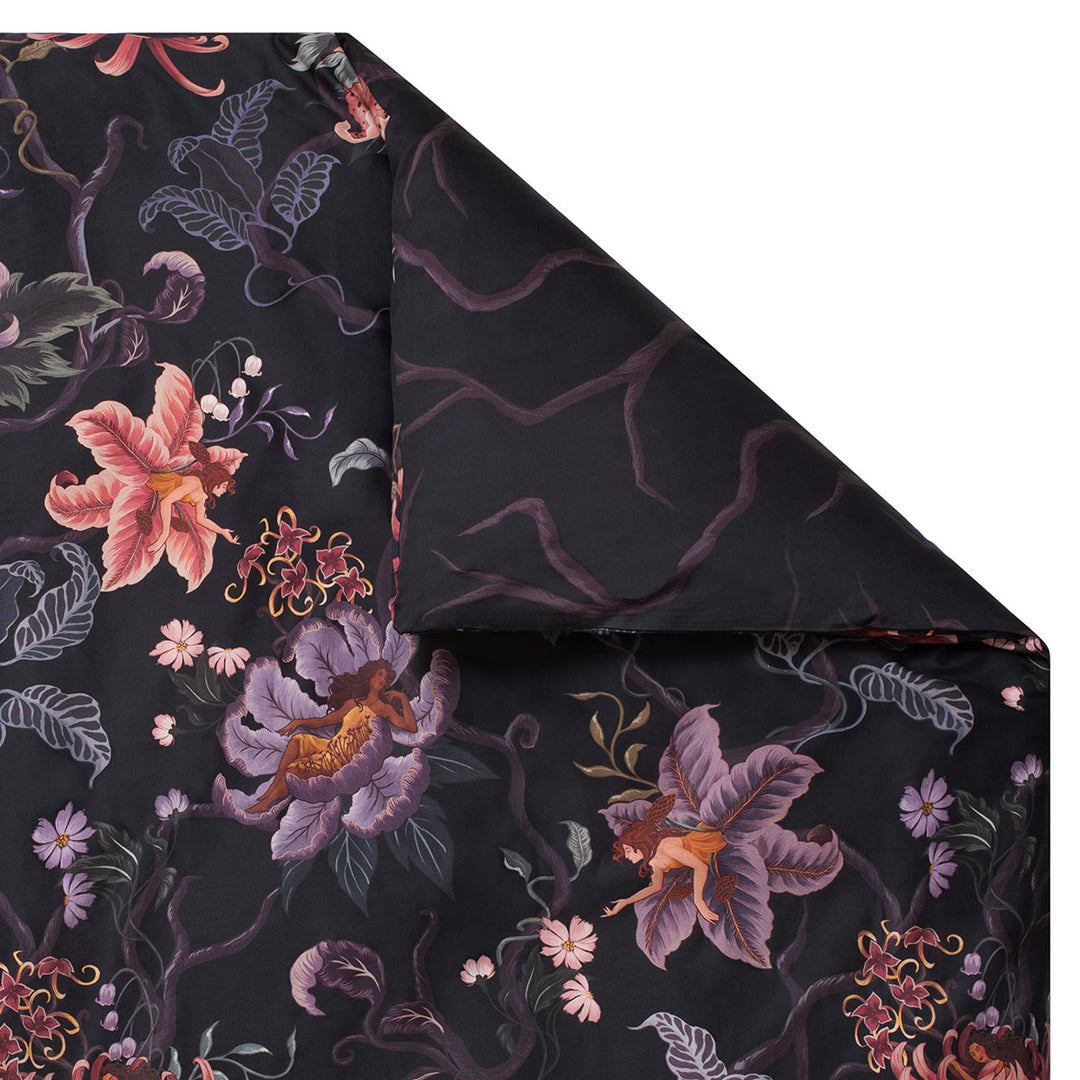 Romantic floral bedding by Sin in Linen. Nymphs bloom out of flowers on a dark background in this fairy inspired bedding collection. Hues of lilac and rose abound. 
