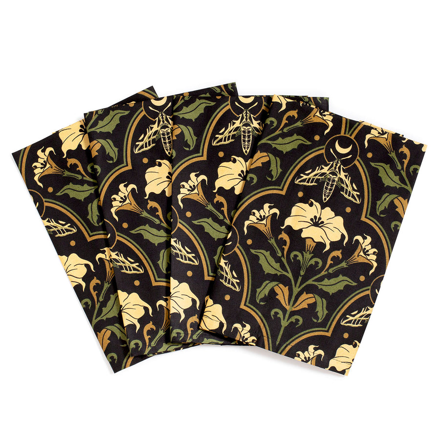 Datura Deco dinner napkins by Sin in Linen on a white background. Gothic Botanical, witchy table linens featuring datura blooms, moths, and moons. 