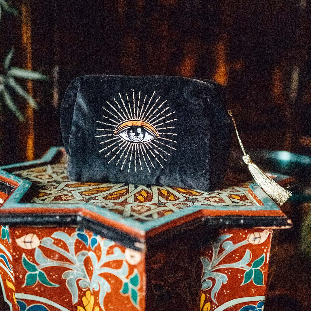Black velvet zipper makeup bag with an embroidered eye on it. Mystical lifestyle items by Sin in Linen.