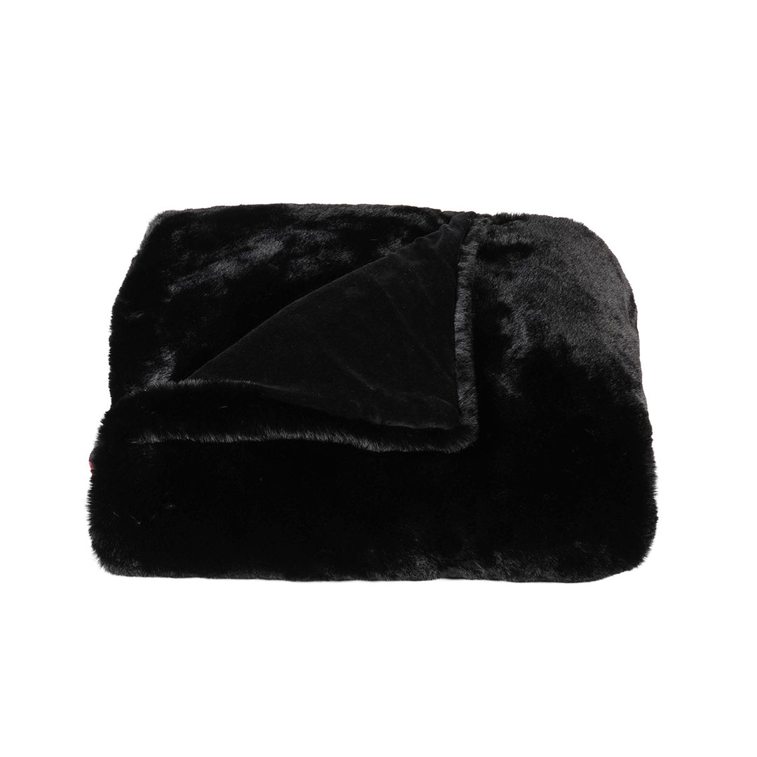 Black faux fur blanket on a white background. Gothic and cozy decor. 
