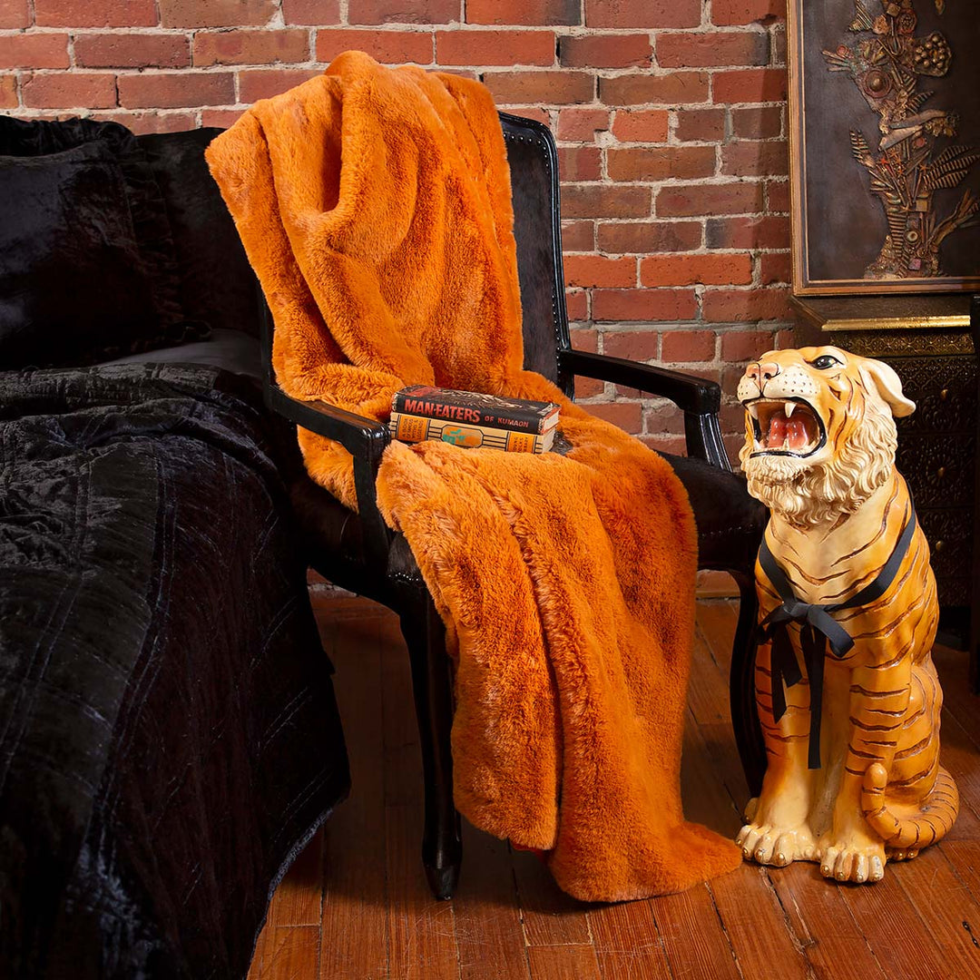 Pumpkin orange faux fur blanket draped across a chair. 
