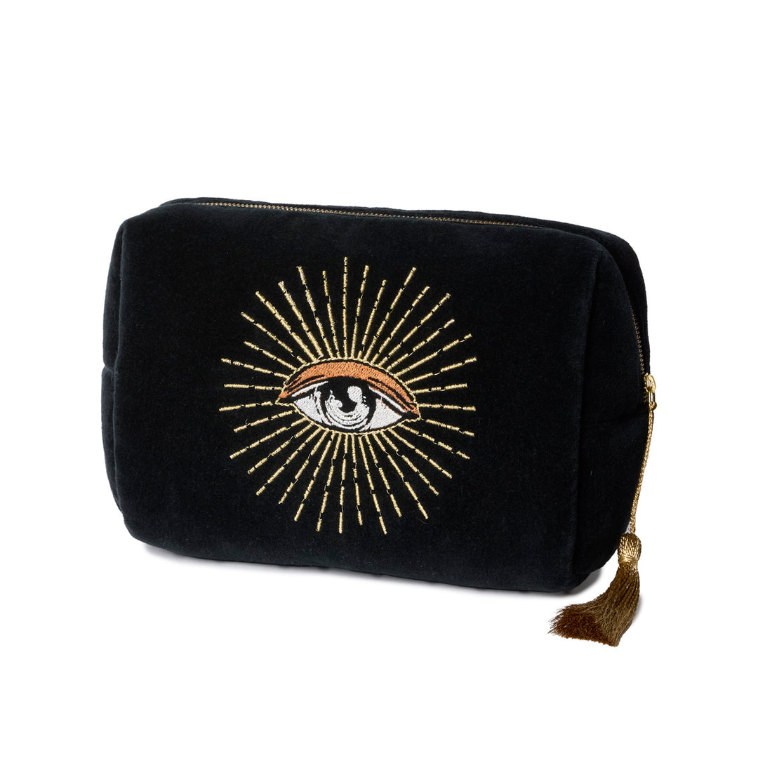 Black velvet toiletry bag with gold embroidered eye design on a white background