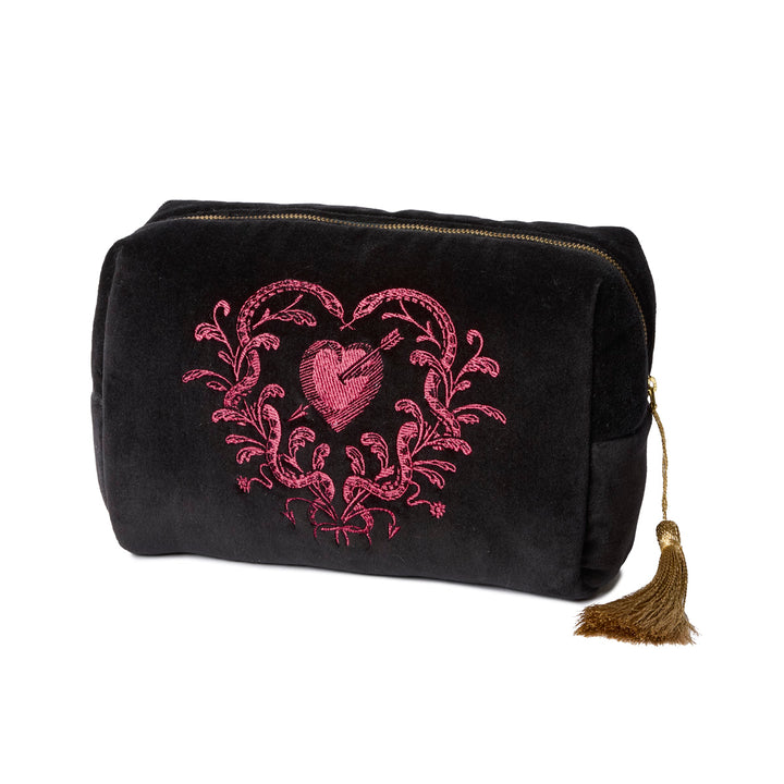 Black velvet toiletry bag with pink heart designs with snakes and gold tassels on a white background