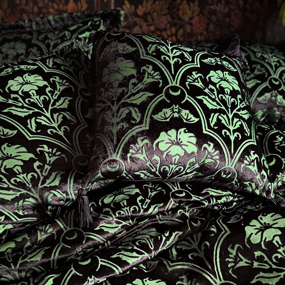 Sin in Linen's Velvet Datura throw pillow. Green gothic botanical pattern featuring datura blooms and bats in a flocked velvet design. Dark witchy throw pillow with tasseled corners.