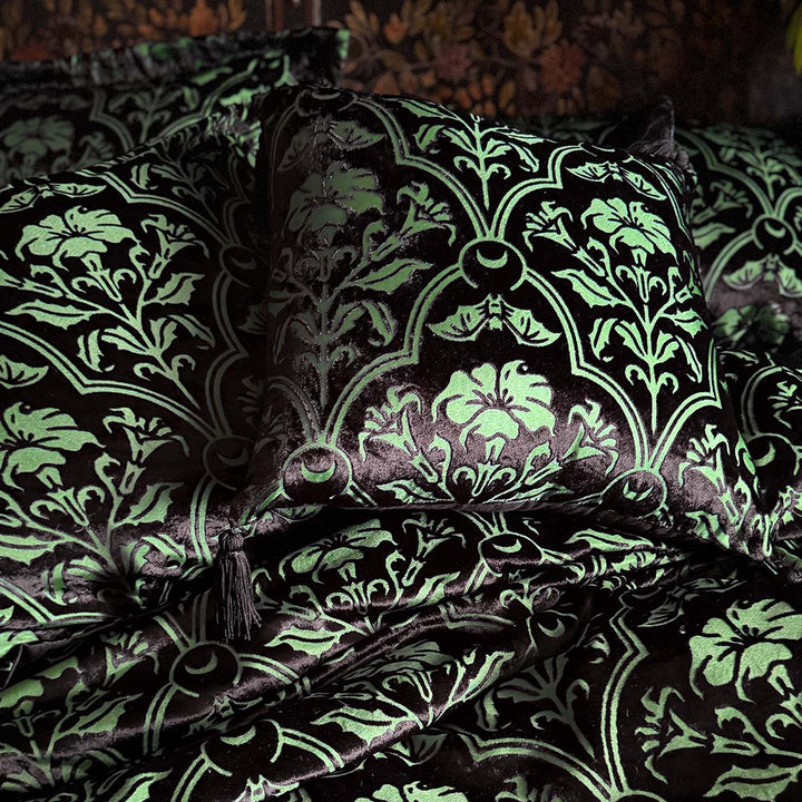Sin in Linen's Velvet Datura throw pillow. Green gothic botanical pattern featuring datura blooms and bats in a flocked velvet design. Dark witchy throw pillow with tasseled corners.