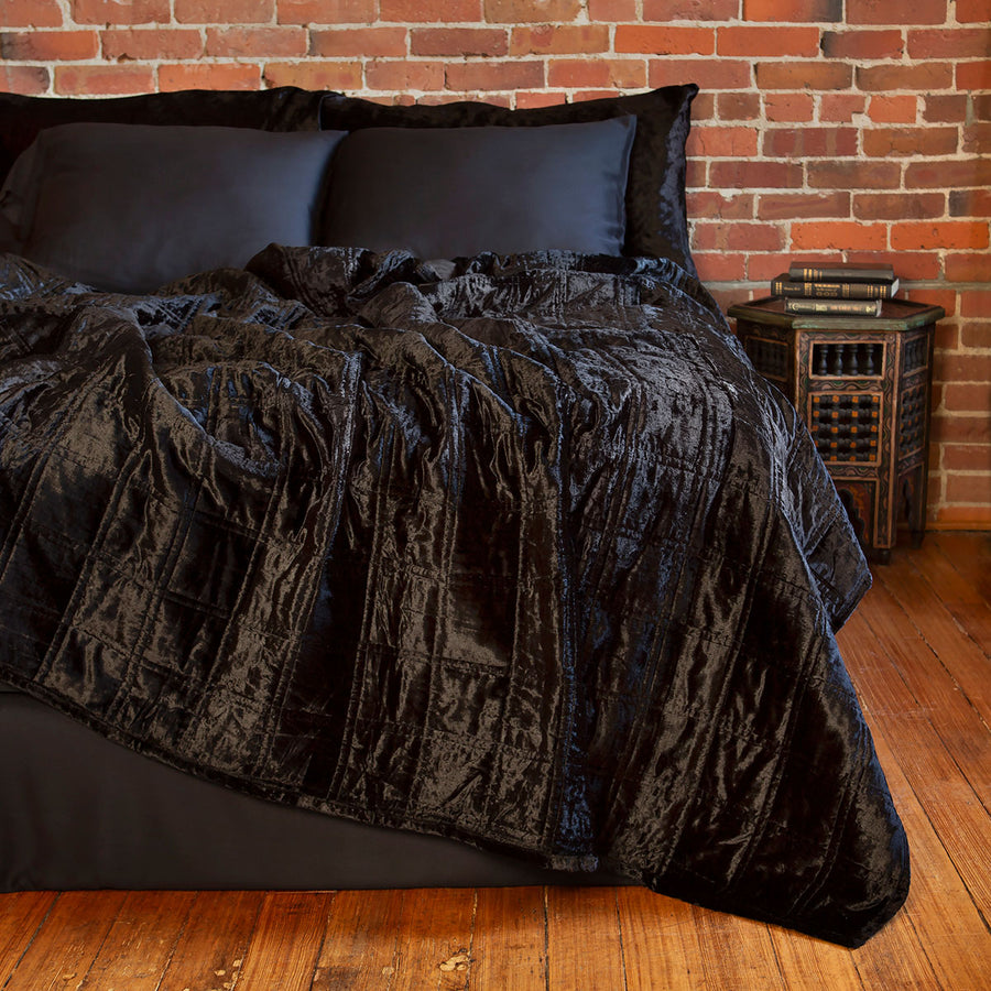 Black velvet box quilt on a bed. Dark velvet bedding. 