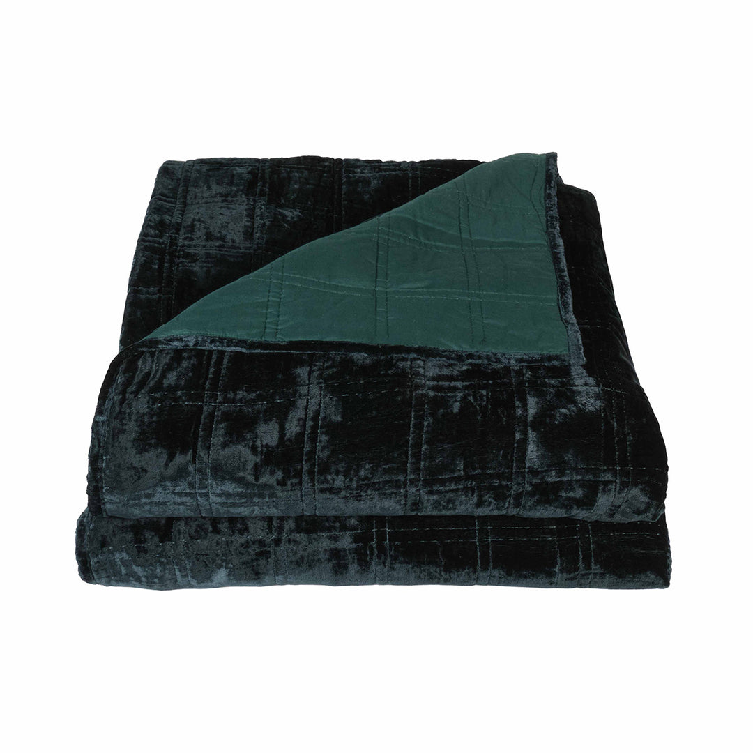 Forest green velvet box quilt on a white background. Dark, moody velvet bedding. 