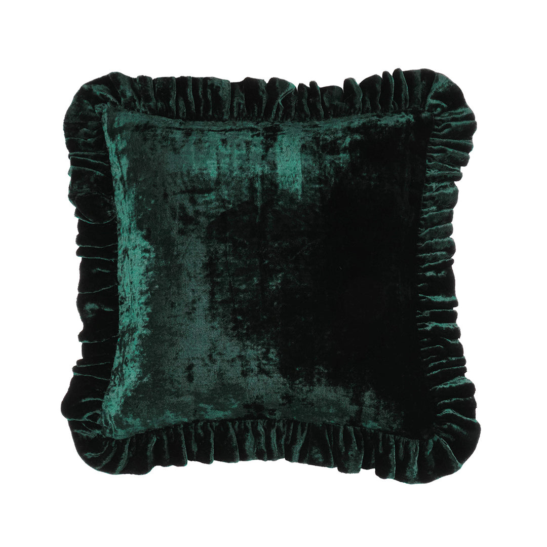 Forest Green velvet throw pillow with a ruffled edge on a bed. 