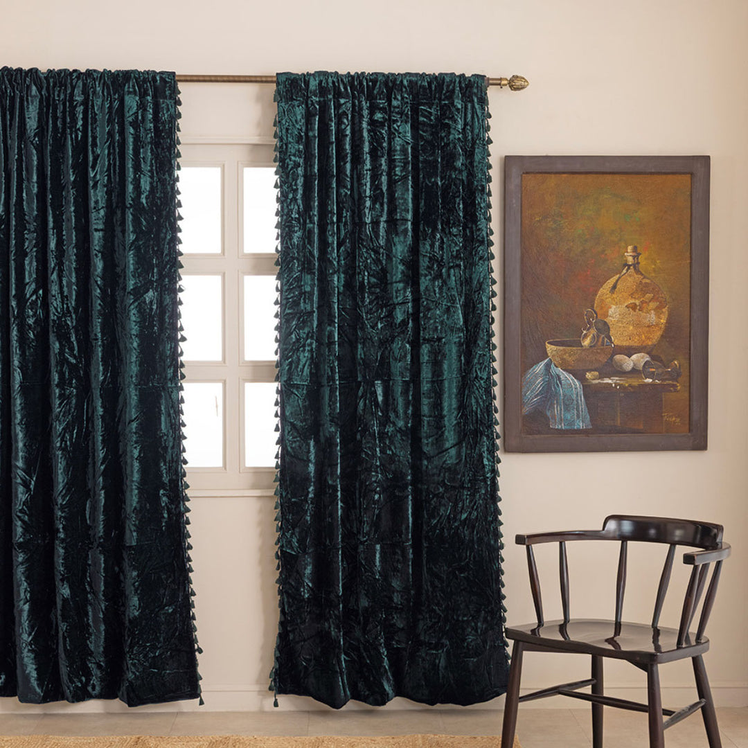 Forest Green velvet tasseled curtains in a room with a chair and a painting. 