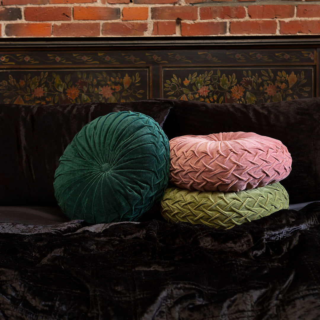 Three velvet pintuck cushions in green, pink, and yellow on a bed with black velvet bedding. Luxurious throw pillows by Sin in Linen. 