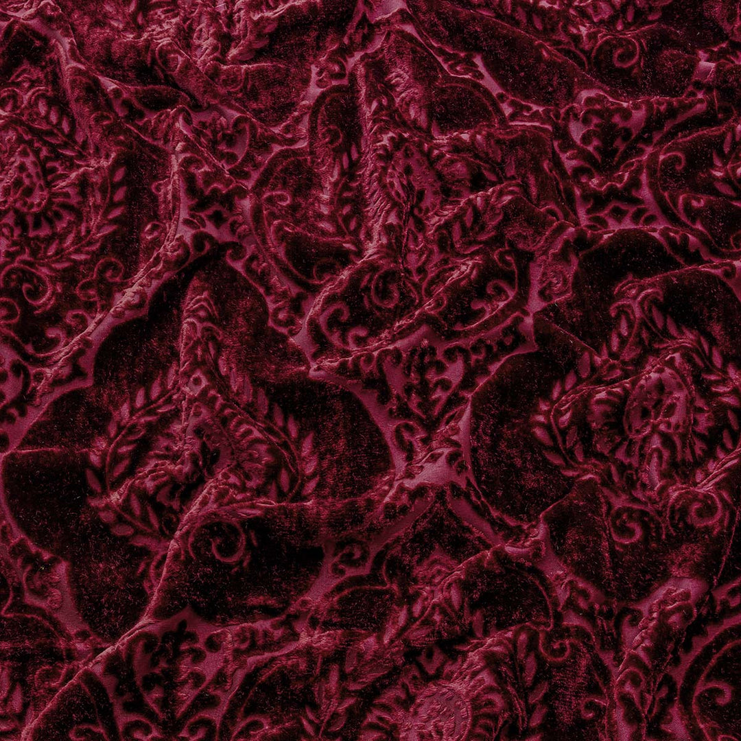Close up of a burgundy velvet curtain to show its texture.