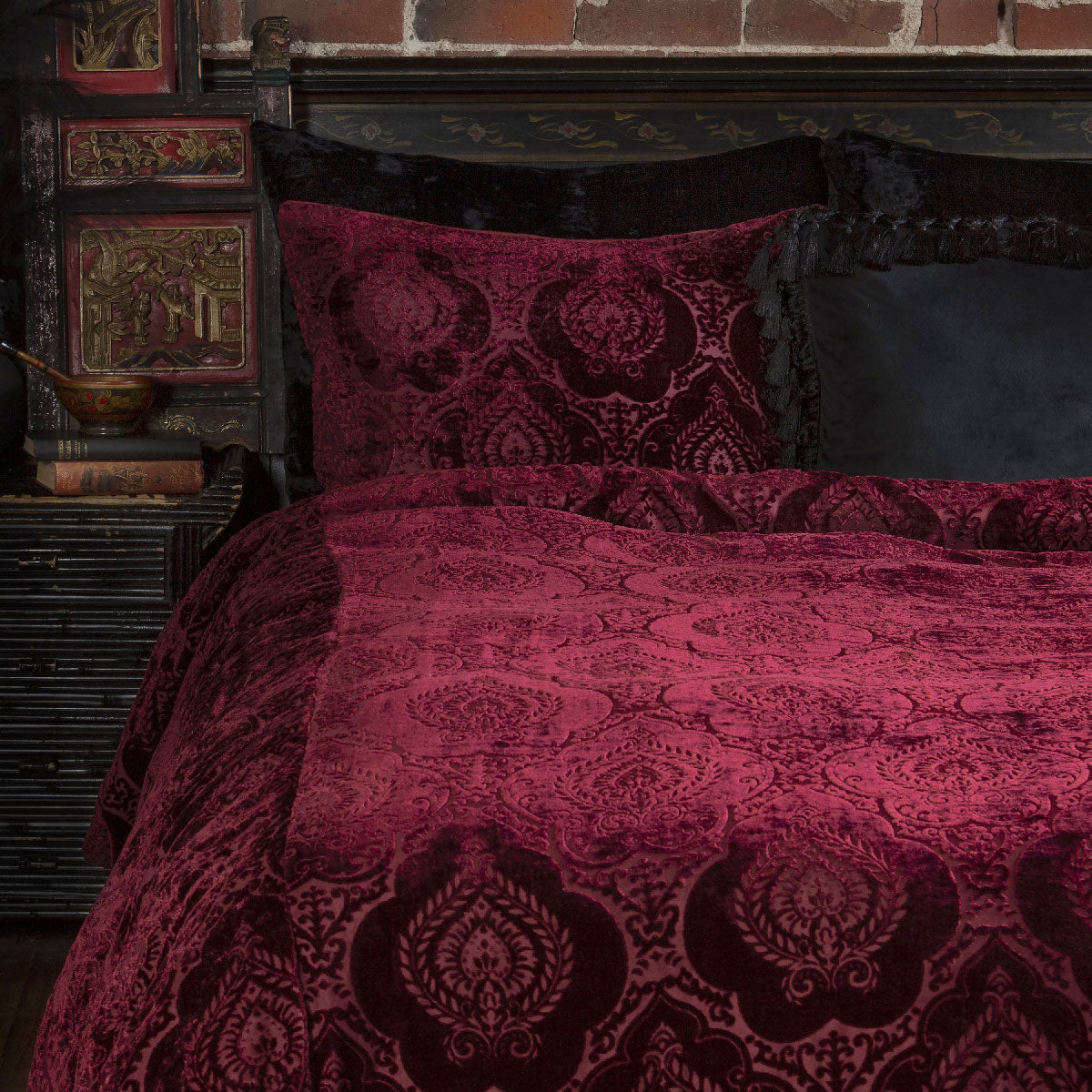 Burgundy velvet bedding with a damask pattern for gothic boudoirs. 
